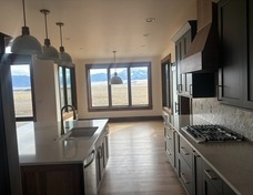 Kitchen rolling into dining nook. Windows all around.