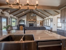 Quartzite countertops, black stainless apron sink with hickory cabinets.